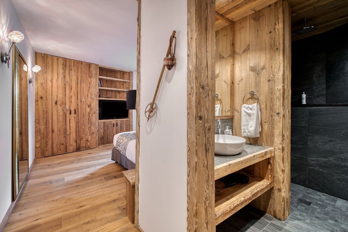 A bathroom with wooden walls and a sink