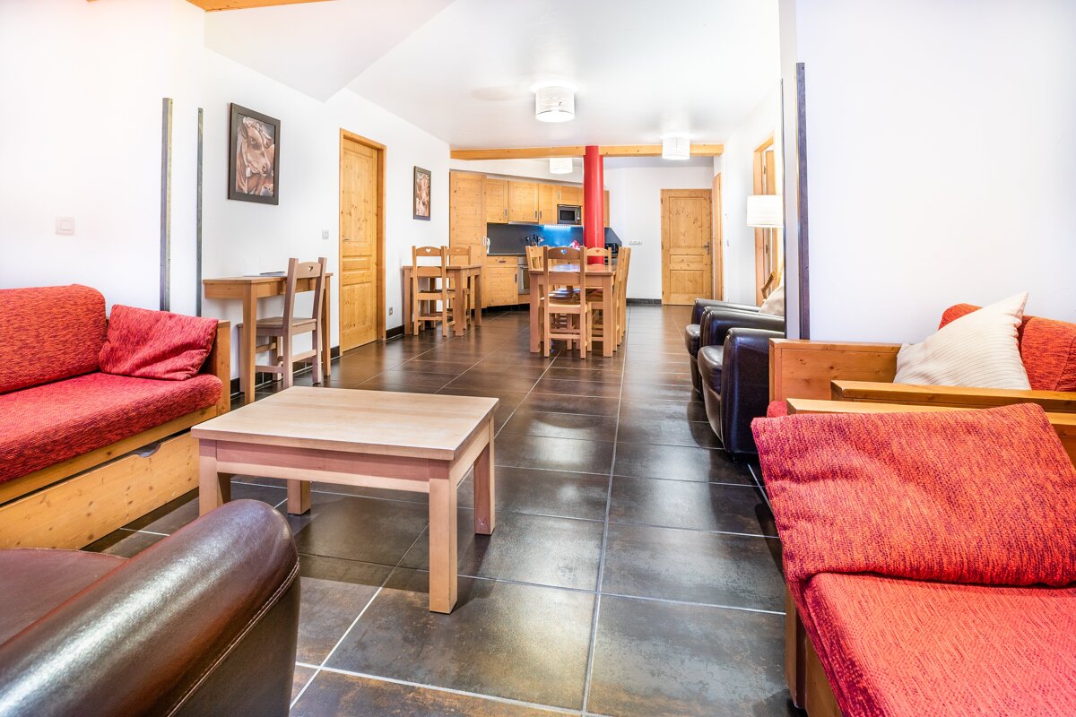 A living room with red furniture and a table