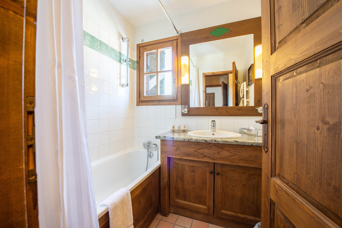 A bathroom with a bathtub sink and mirror