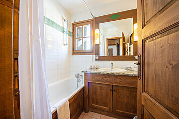 A bathroom with a bathtub sink and mirror