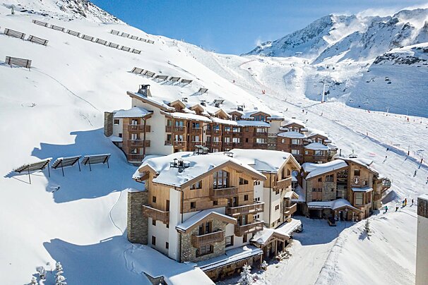 A ski resort with a few buildings covered in snow