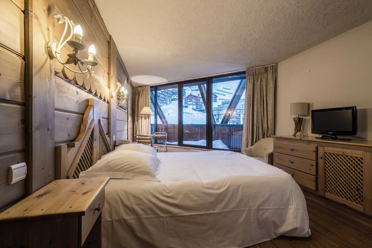 A bedroom with a large bed and a television