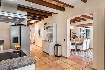 A kitchen with a stainless steel refrigerator and a stove top oven