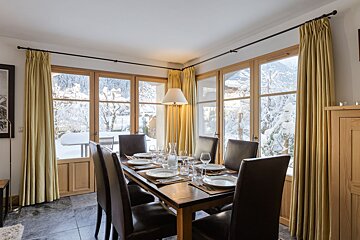 A dining room with a table and chairs and a lamp