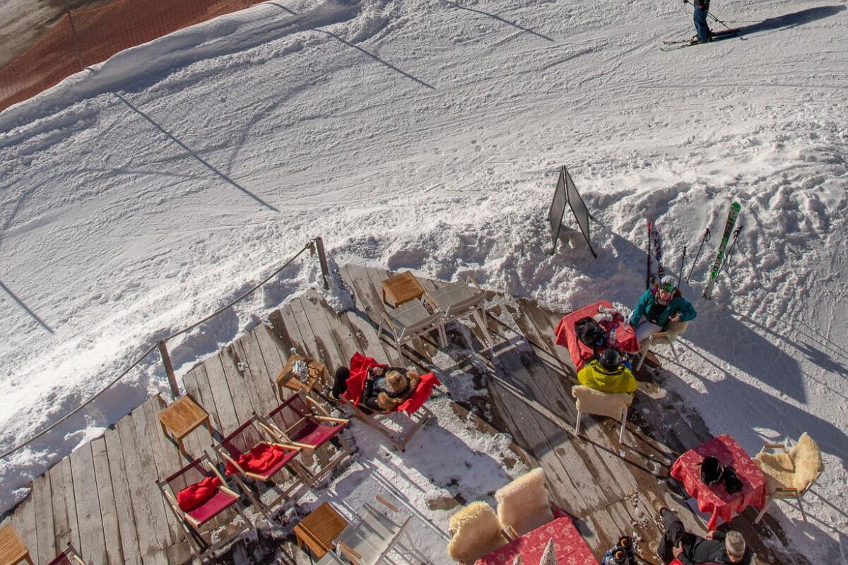 A group of people sit at tables in the snow