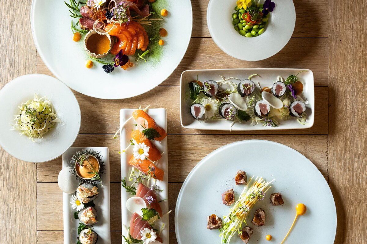 A variety of plates of food on a wooden table