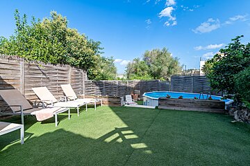 A backyard with lawn chairs and a swimming pool