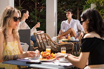 A group of people are sitting around a table eating and drinking