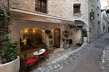 A restaurant called le saint paul sits on a cobblestone street
