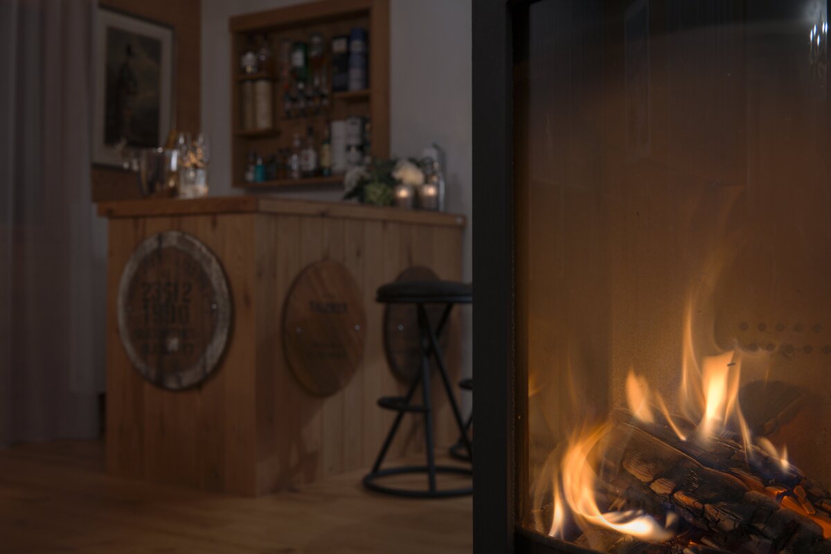 A fireplace with a wooden bar in the background