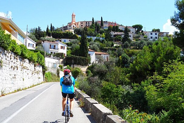 a man cycling down a road to Aspremont, Nice