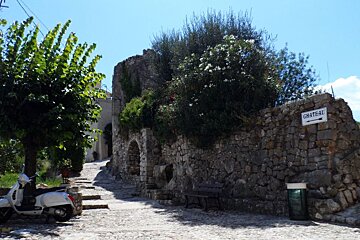 a sign on a stone wall pointing to a chateau