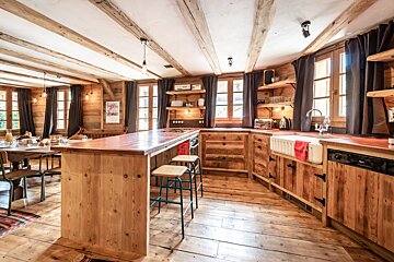 A kitchen with wooden cabinets and a large island