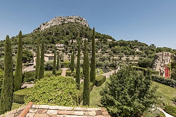 A view of a hillside with trees and houses in the background