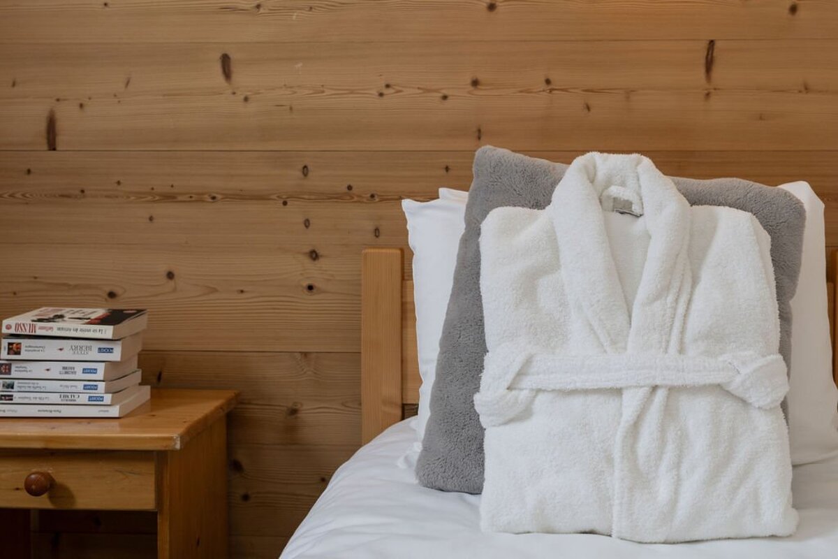 A bed with a robe and a pillow on it