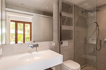 A bathroom with a toilet a sink and a shower