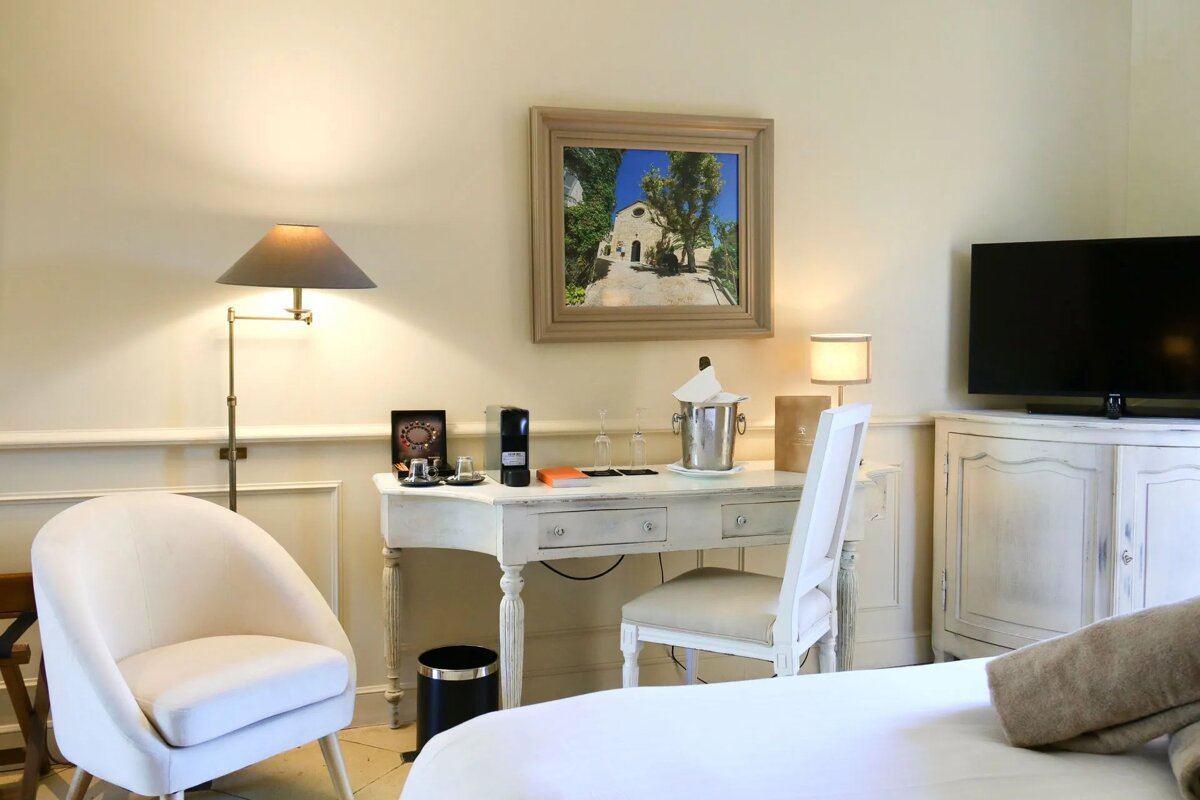 A hotel room with a desk chair and television