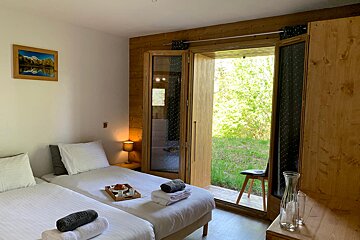 A bedroom with two beds and a picture on the wall