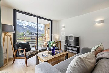 A living room with a couch a chair and a flat screen tv
