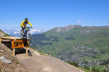a mountain biker jumping off a feature