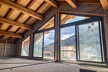 A building under construction with a lot of windows and a roof