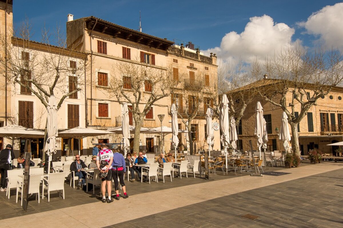 cyclist & other tourists in the main square at Pollenca