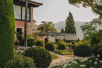 A lush green garden with a house in the background