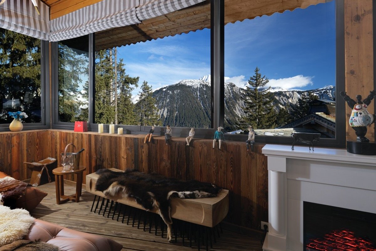 A living room with a fireplace and a view of the mountains