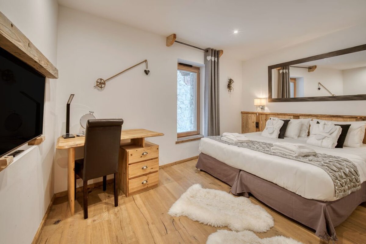 A bedroom with a large bed and a large mirror