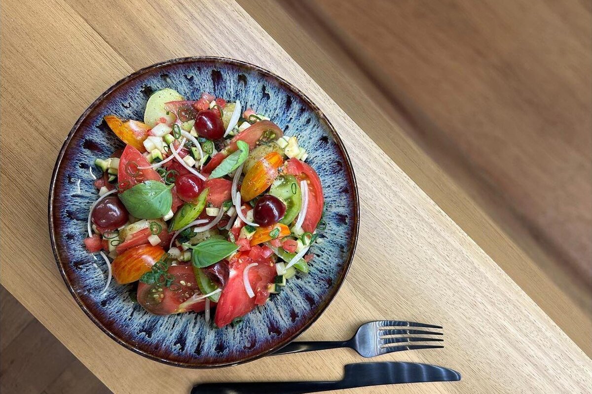 A salad with tomatoes and other vegetables on a blue plate