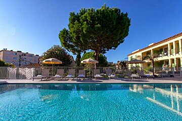 A large swimming pool surrounded by chairs and umbrellas