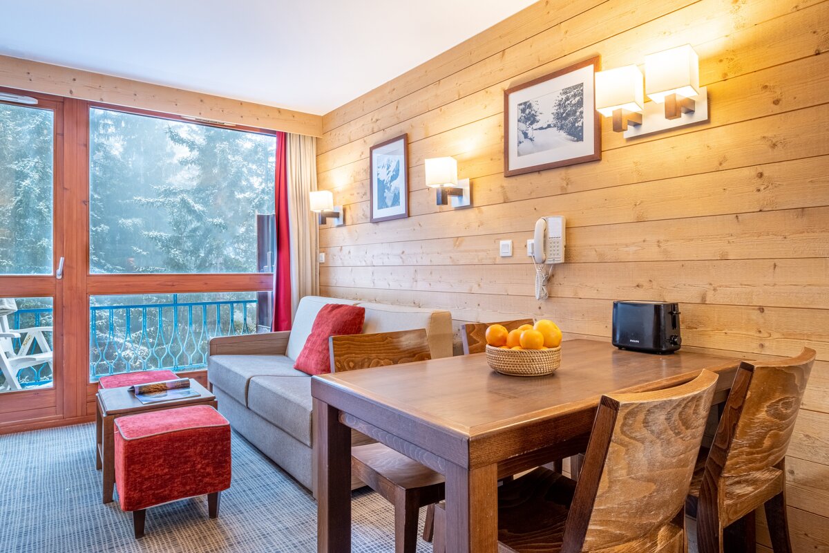 A living room with a couch a table and chairs