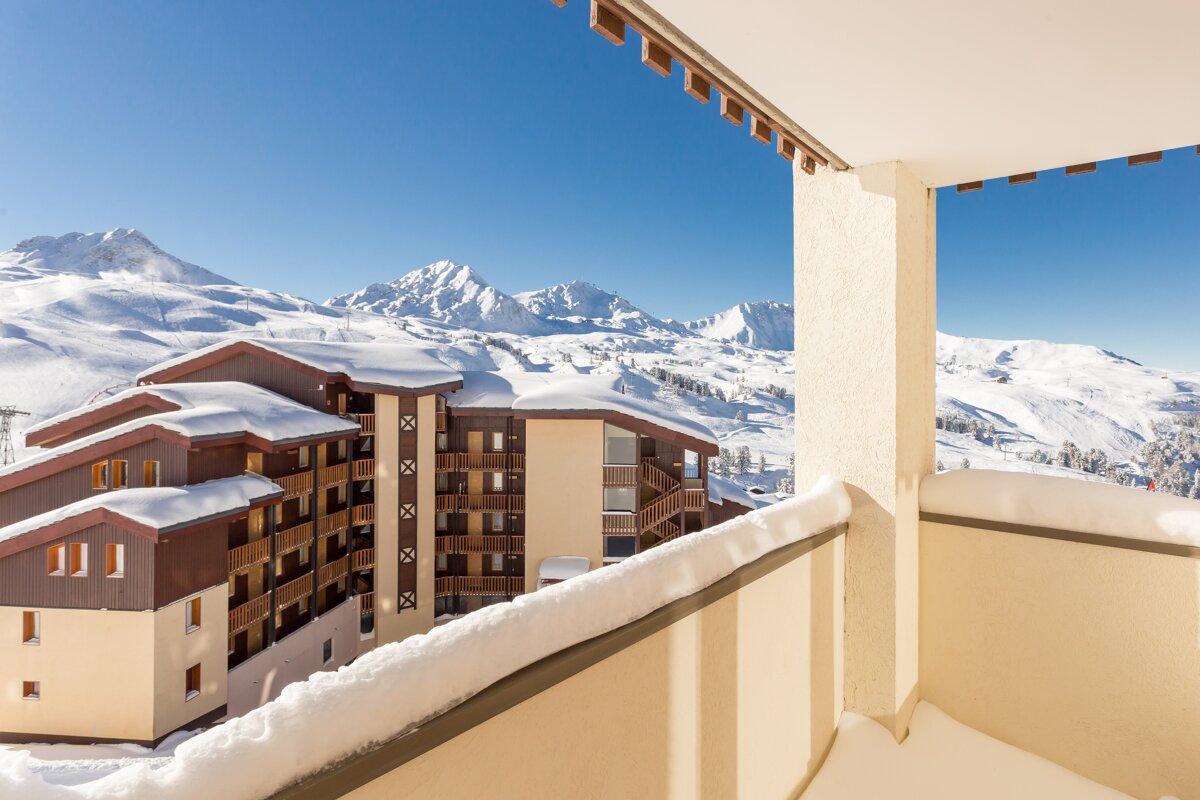 A balcony with a view of a snowy mountain range