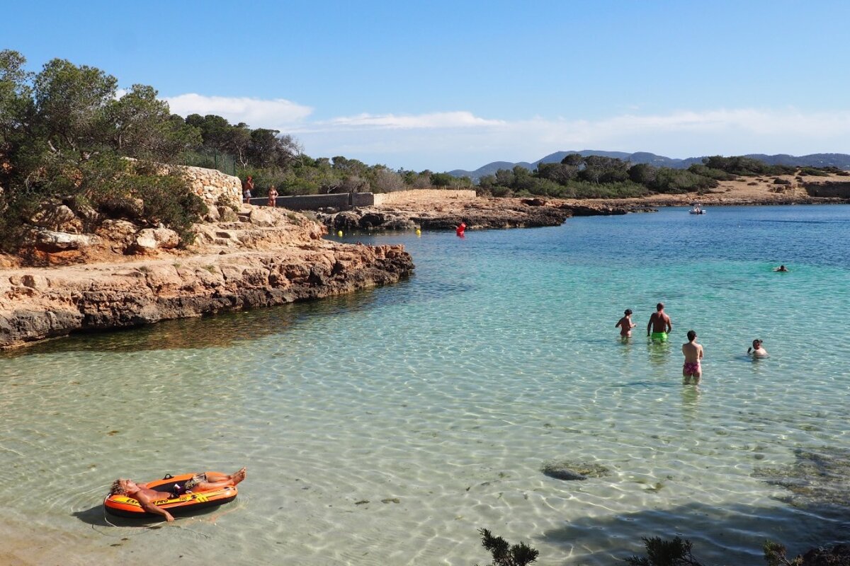 people in the water at a beach in west ibiza