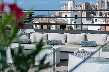 A rooftop terrace lounge with comfy seating and 