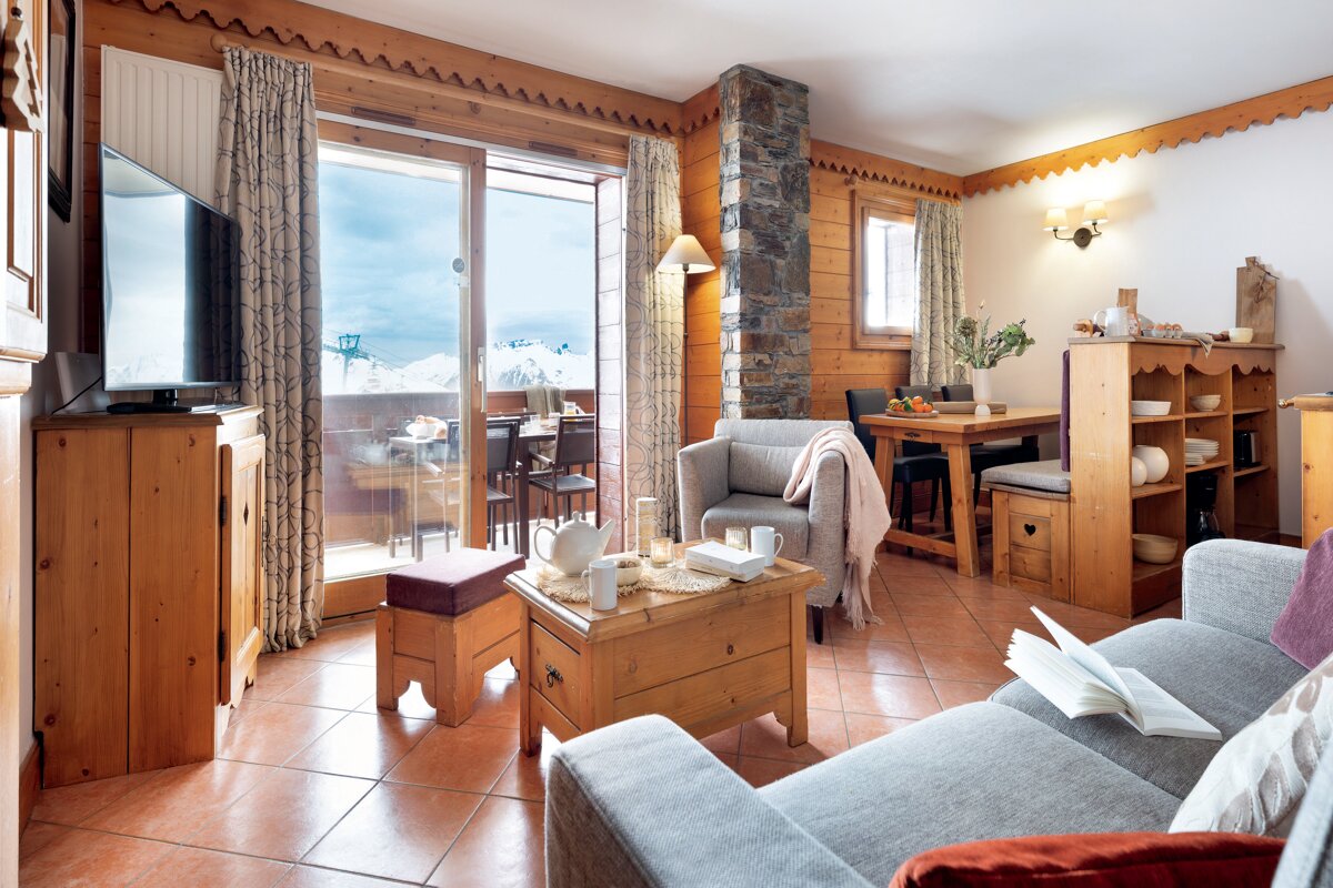 A living room with a couch a chair a table and a television