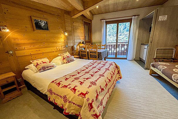 A bedroom with a large bed and a smaller bed