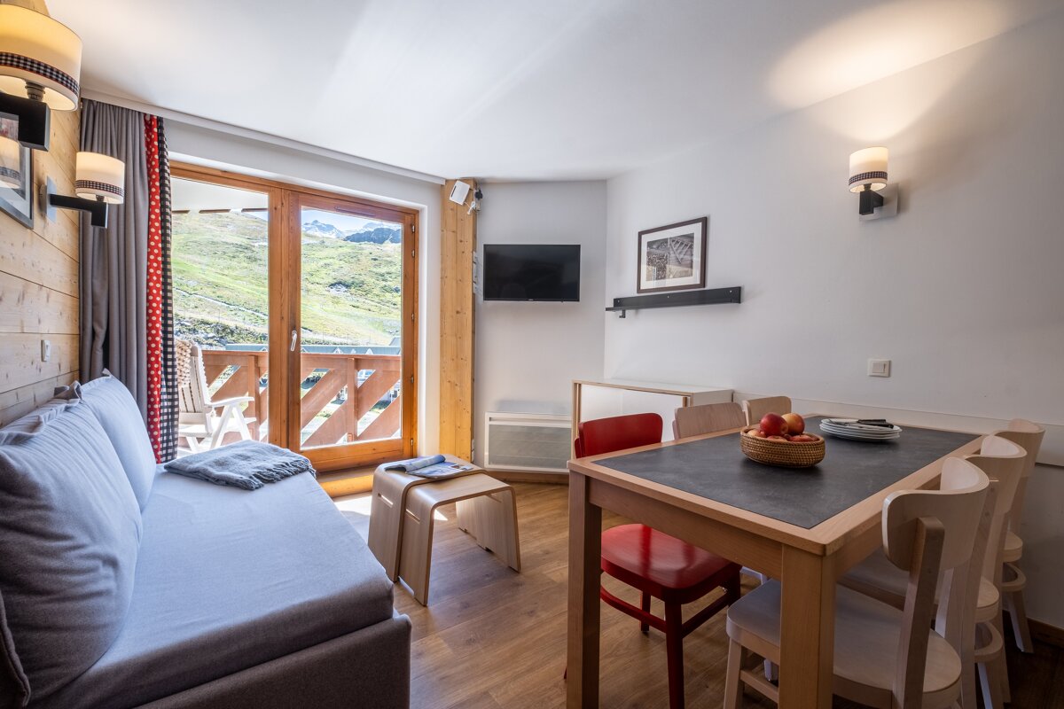 A living room with a couch a table and chairs