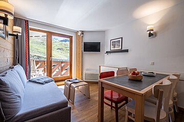 A living room with a couch a table and chairs