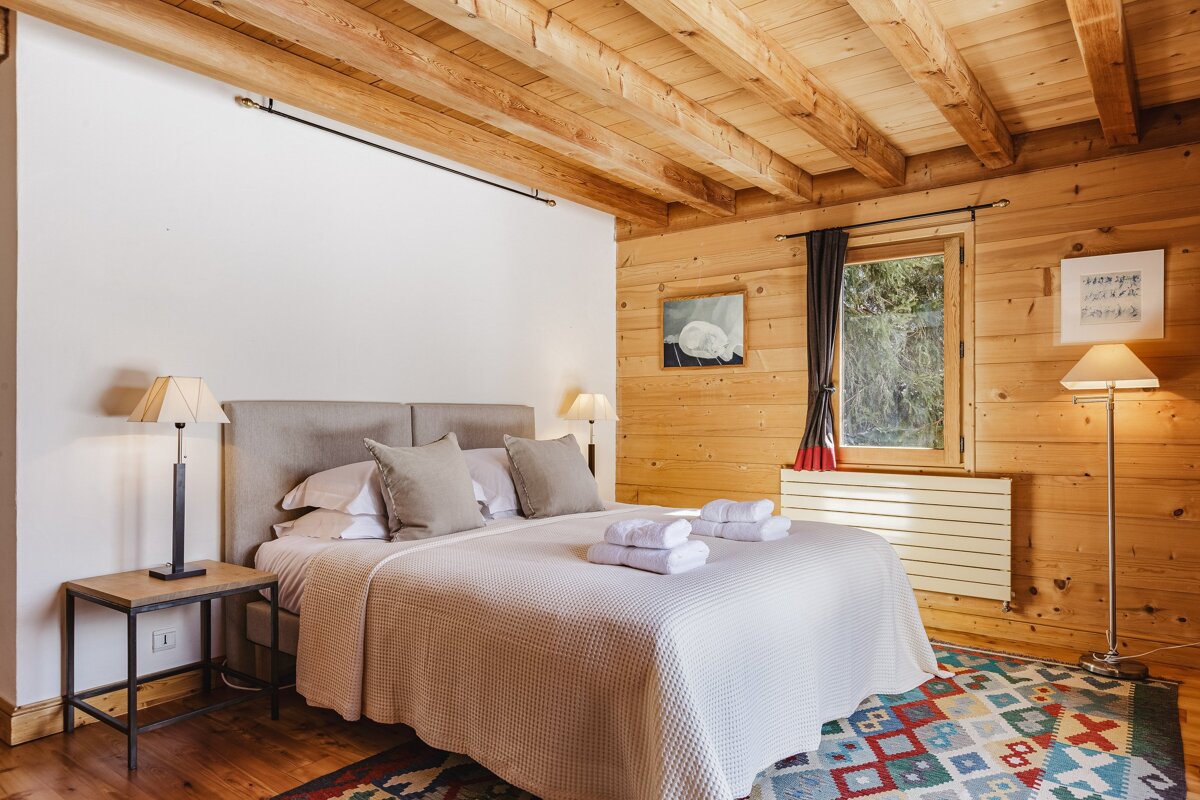 A bedroom with a king size bed and a rug