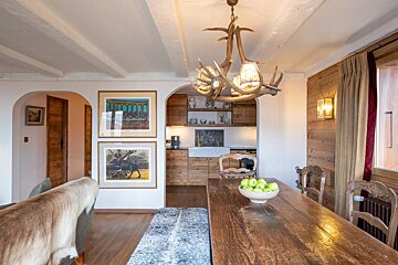 A dining room table with a bowl of apples on it