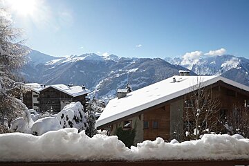 A snow covered roof with mountains in the background