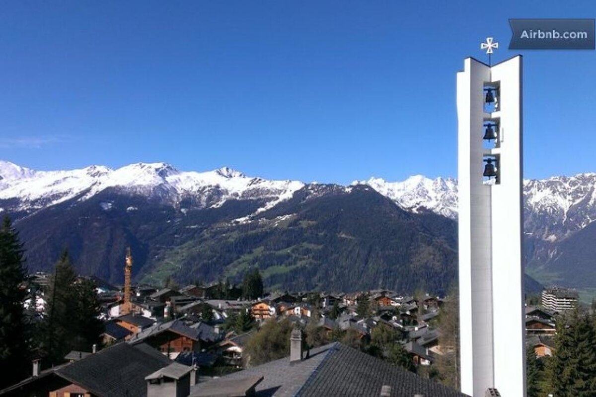 A picture of a church with mountains in the background is on airbnb.com