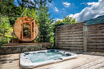 A hot tub with a wooden sauna in the background