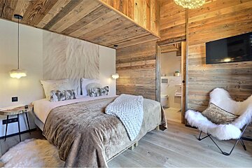 A bedroom with a king size bed and a chair