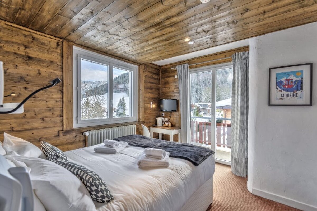 A hotel room with a picture of morzine on the wall