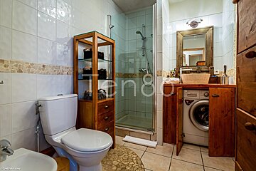 A bathroom with a toilet a sink and a washing machine with the word tengo on the bottom