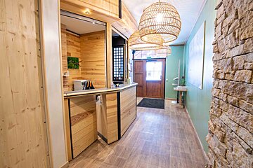 A hallway with a wooden counter and wicker lamps