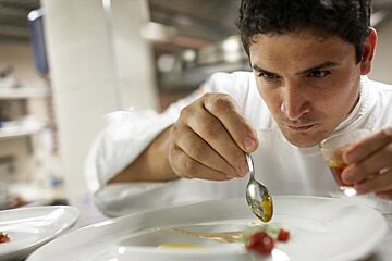a chef finishing some plates