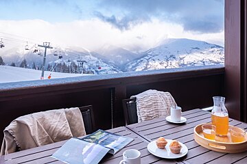 A table with a magazine and a pitcher of orange juice